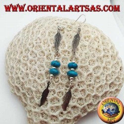 Pendientes colgantes de plata con discos de turquesa y bolas entre dos plumas.