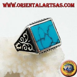 Anillo de plata con turquesas cuadradas, grabados de rombos arriba y abajo y decoraciones de alto relieve en los lados