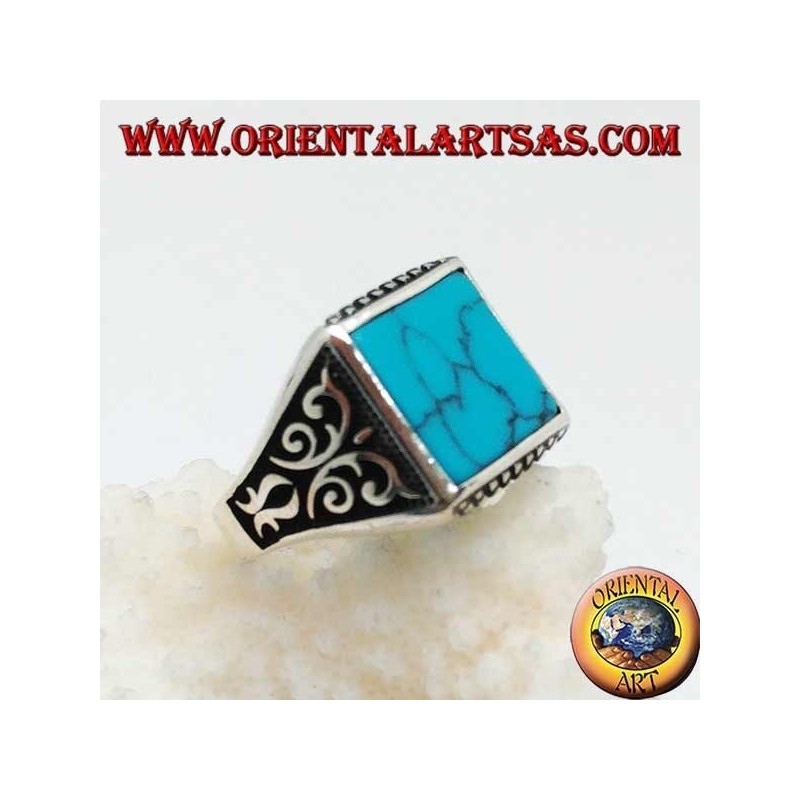 Anillo de plata con turquesas cuadradas, grabados de rombos arriba y abajo y decoraciones de alto relieve en los lados