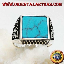 Anillo de plata con turquesas cuadradas, grabados de rombos arriba y abajo y decoraciones de alto relieve en los lados