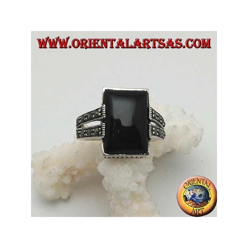 Anillo de plata con ónix rectangular en un marco punteado con dos grapas con marcasita en los lados