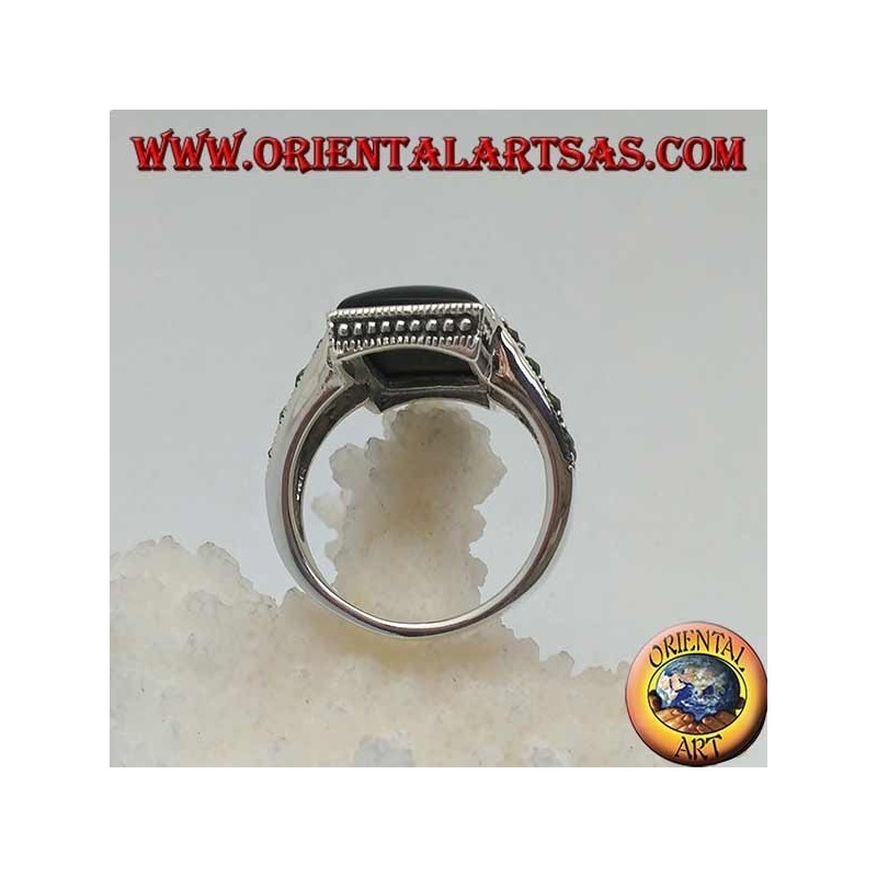 Silberring mit rechteckigem Onyx in einem gepunkteten Rahmen mit zwei Heftklammern mit Markasit an den Seiten