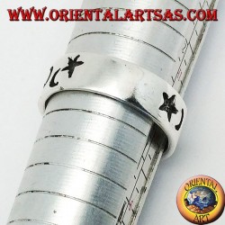 Anillo de plata lisa con gruesos grabados de estrellas y lunas.