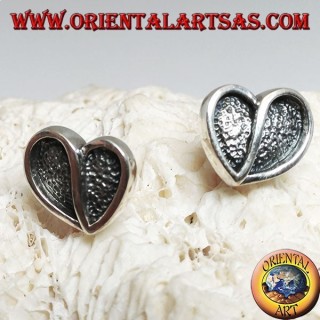 Heart-shaped silver earrings hollowed out in bas-relief from a lobe