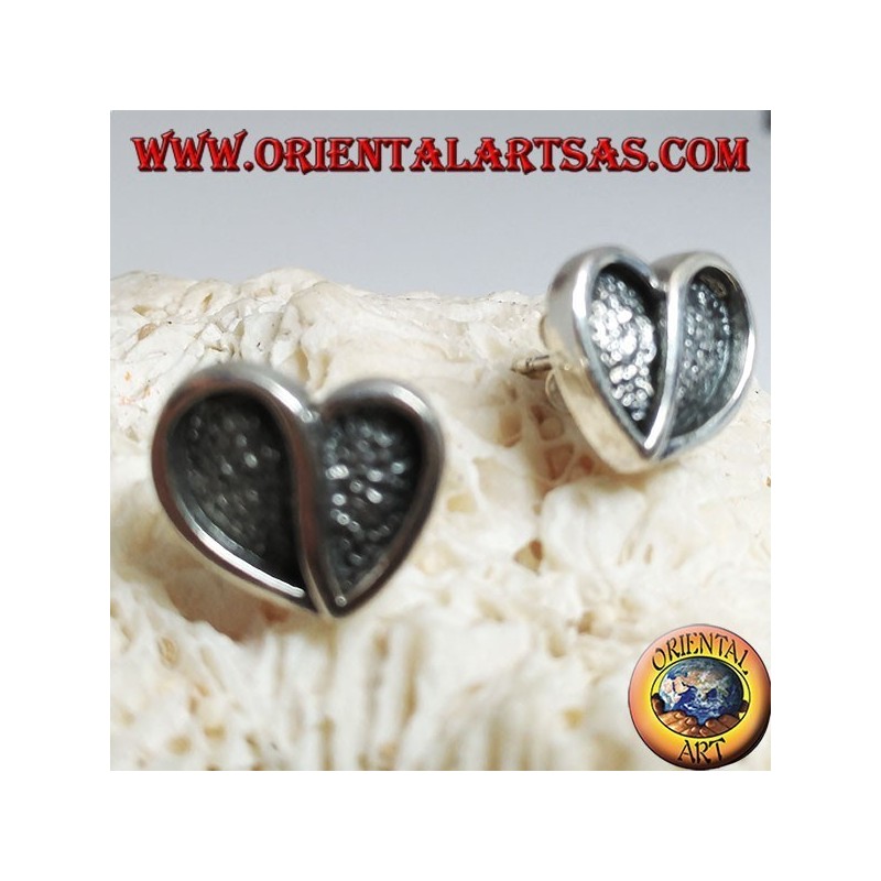 Heart-shaped silver earrings hollowed out in bas-relief from a lobe