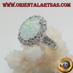 Anillo de plata con ópalo arlequín ovalado engastado con circonitas alrededor y a los lados.