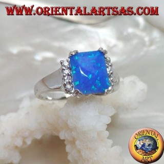 Anello in argento con opale blu rettangolare incastonato a quattro e fila di zirconi sui lati