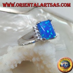 Anillo de plata con ópalo rectangular azul en cuatro y fila de circonitas en los lados.