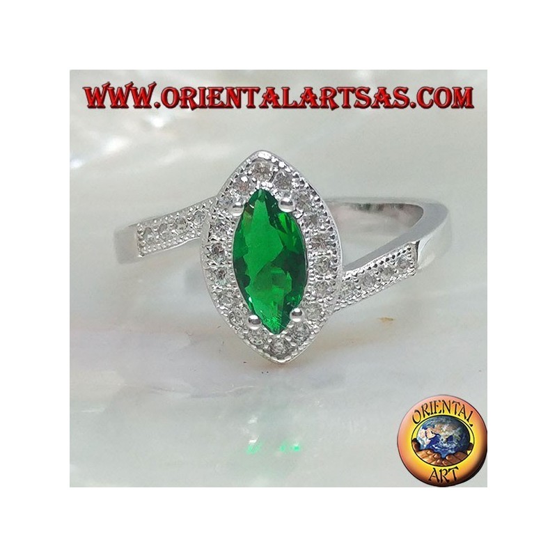 Anillo de plata con esmeralda lanzadera sintética, rodeado de circonitas en un marco asimétrico.