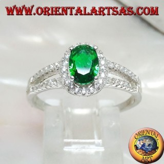 Anillo de plata con esmeralda ovalada sintética engastada rodeada de circonitas y dos líneas laterales.