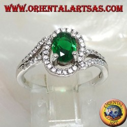 Anillo de plata con esmeralda sintética ovalada, rodeado de circonitas en una configuración concéntrica