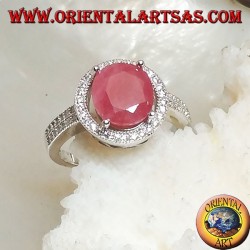 Silver ring with oval natural ruby set on a round frame with zircons