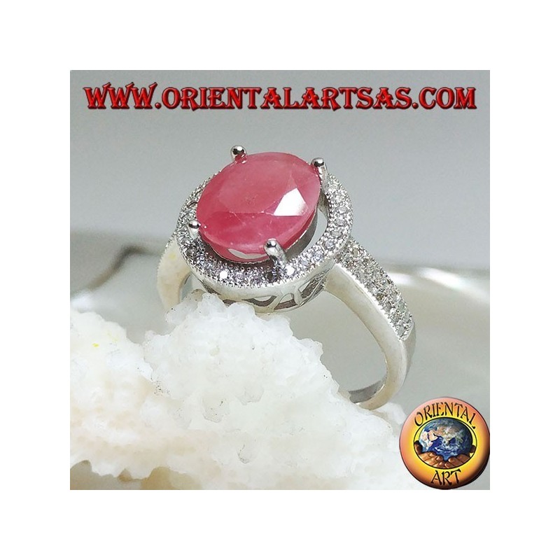 Silver ring with oval natural ruby set on a round frame with zircons