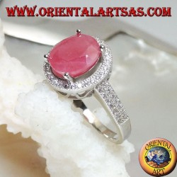 Silver ring with oval natural ruby set on a round frame with zircons