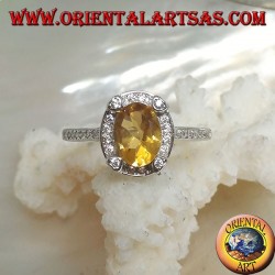 Silver ring with oval natural yellow topaz surrounded by cubic zirconia and with four cubic zirconia in relief