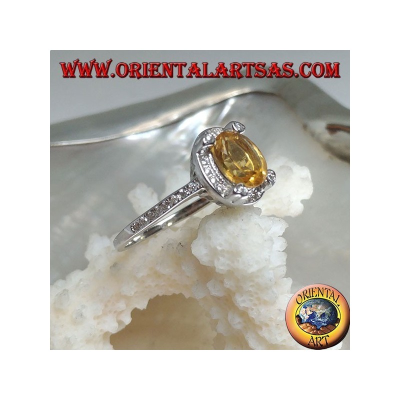 Silver ring with oval natural yellow topaz surrounded by cubic zirconia and with four cubic zirconia in relief