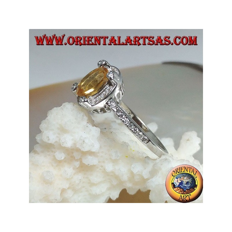 Silver ring with oval natural yellow topaz surrounded by cubic zirconia and with four cubic zirconia in relief