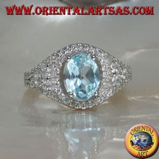 Bague en argent avec topaze bleue naturelle ovale sur un cadre clouté de zircon et trois tours sur les côtés