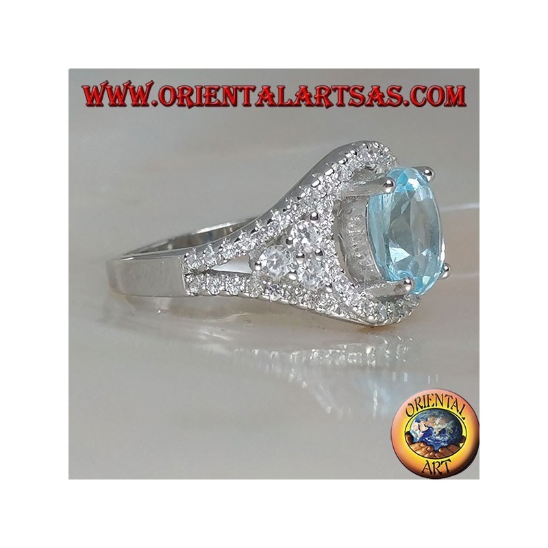 Silver ring with oval natural blue topaz on a zircon-studded frame and three rounds on the sides