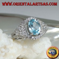 Silver ring with oval natural blue topaz on a zircon-studded frame and three rounds on the sides