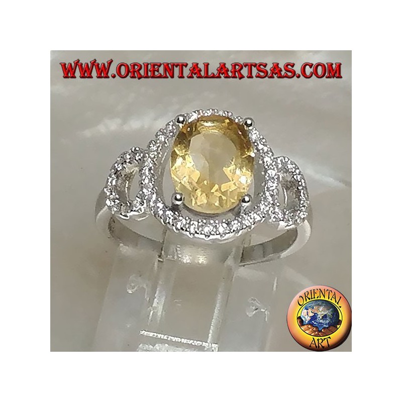 Silver ring with oval natural yellow topaz set on a three circle of zirconia setting