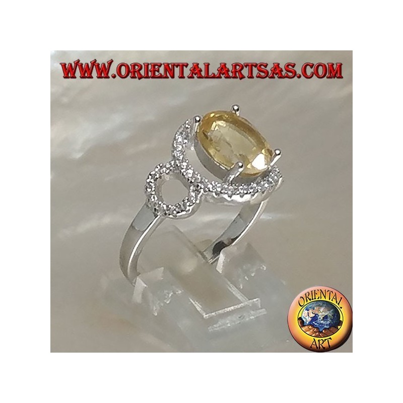 Anillo de plata con topacio amarillo natural ovalado engastado en una configuración de circonita de tres círculos