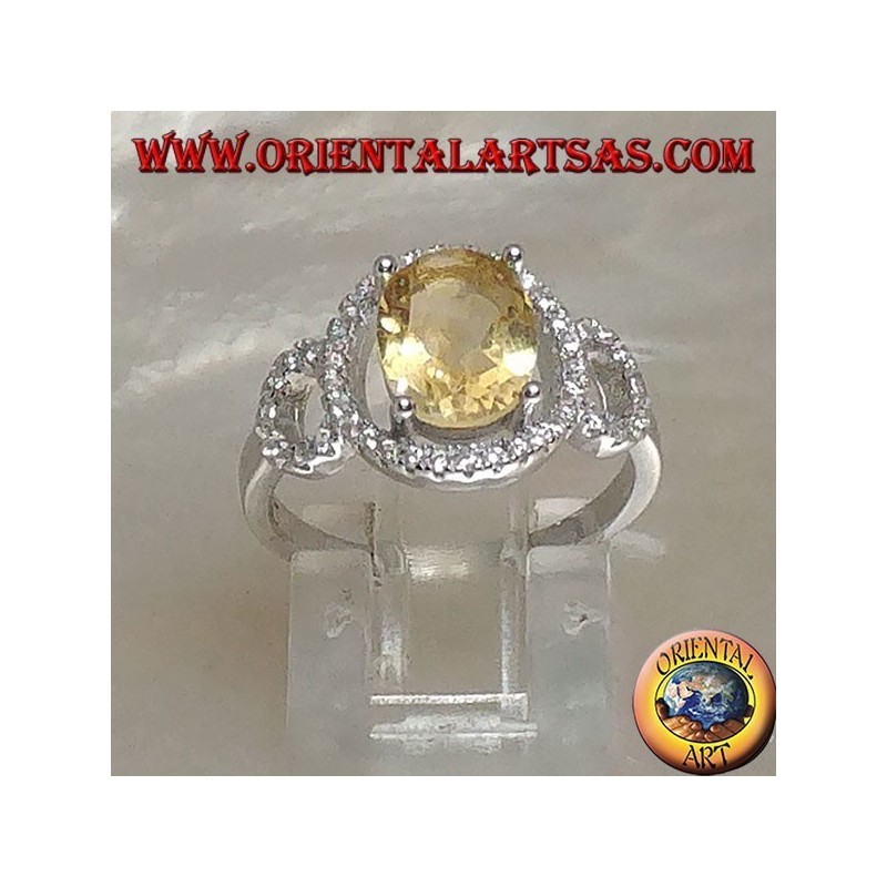 Anillo de plata con topacio amarillo natural ovalado engastado en una configuración de circonita de tres círculos
