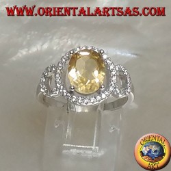 Anillo de plata con topacio amarillo natural ovalado engastado en una configuración de circonita de tres círculos