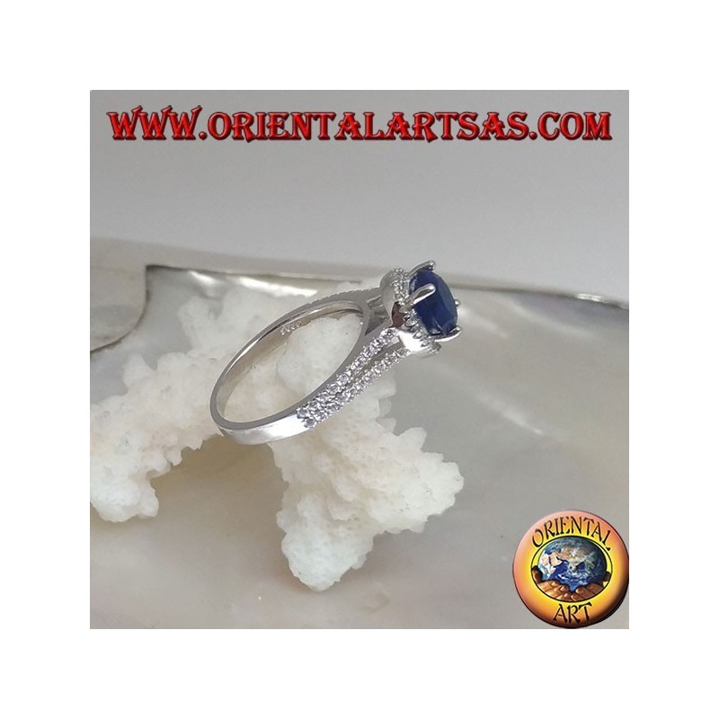 Silver ring with round synthetic sapphire set surrounded by raised zircons