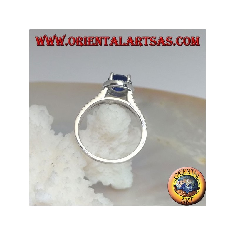 Silver ring with round synthetic sapphire set surrounded by raised zircons