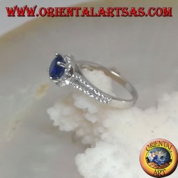 Silver ring with round synthetic sapphire set surrounded by raised zircons