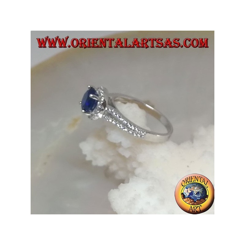 Anello in argento con zaffiro sintetico tondo incastonato contornato da zirconi sopraelevato