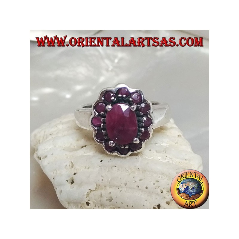 Anillo de plata con rubí natural ovalado, rodeado de pequeños rubíes redondos.
