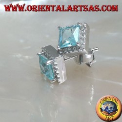 Pendientes de plata con topacio azul natural engastados en un cuadrado rodeado de circonitas.