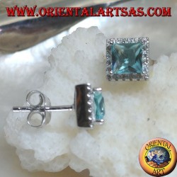 Pendientes de plata con topacio azul natural engastados en un cuadrado rodeado de circonitas.