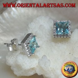 Pendientes de plata con topacio azul natural engastados en un cuadrado rodeado de circonitas.