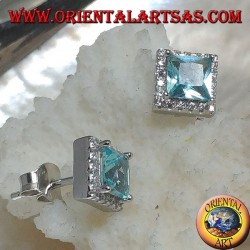 Pendientes de plata con topacio azul natural engastados en un cuadrado rodeado de circonitas.