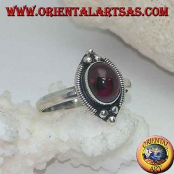 Silver ring with oval cabochon garnet surrounded by intertwining and three balls above and below
