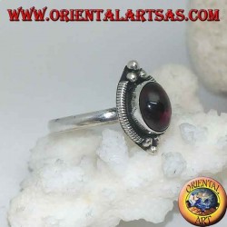 Silver ring with oval cabochon garnet surrounded by intertwining and three balls above and below