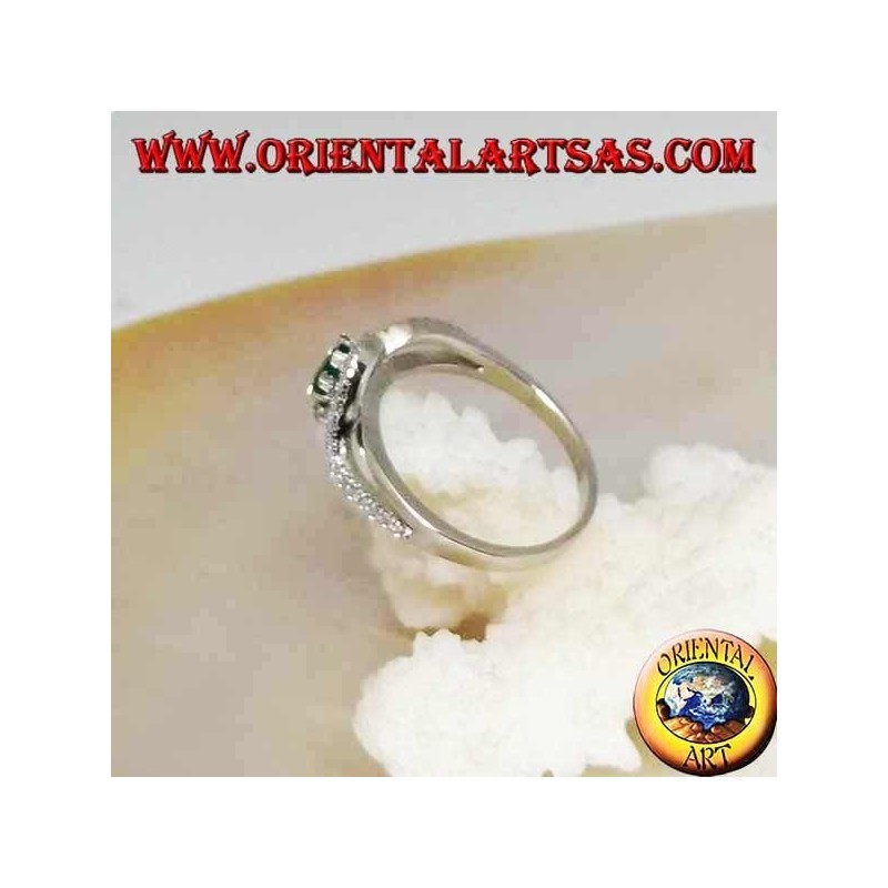 Anillo de plata con esmeralda redonda natural engastada en una tira de circonitas.