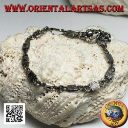 Pulsera de plata suave con placas grabadas con bajorrelieve alternando con anillos.