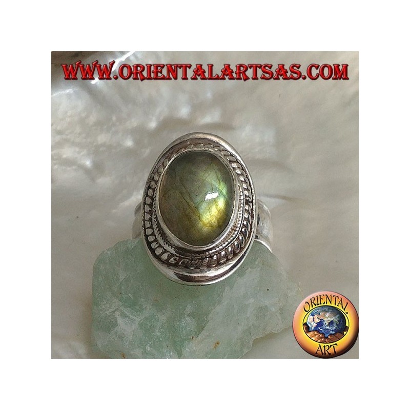 Silver ring with oval cabochon labradorite surrounded by intertwining on a smooth shield