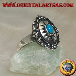 Escudo anillo de plata decorado con turquesa central ovalada en sol grabado y flores en el borde