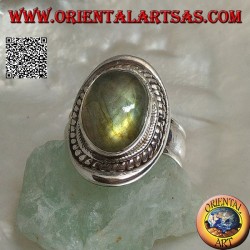 Silver ring with oval cabochon labradorite surrounded by intertwining on a smooth shield