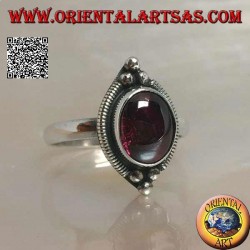 Silver ring with oval cabochon garnet surrounded by stripes and tris of balls above and below