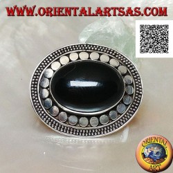 Silver brooch with large oval onyx cabochon surrounded by discs and two strings of dots