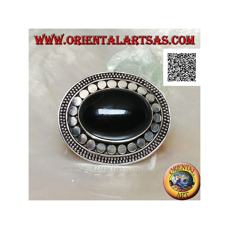 Silver brooch with large oval onyx cabochon surrounded by discs and two strings of dots