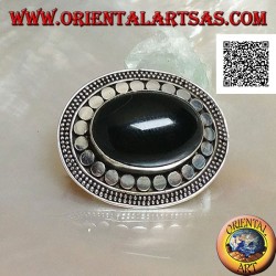 Silver brooch with large oval onyx cabochon surrounded by discs and two strings of dots