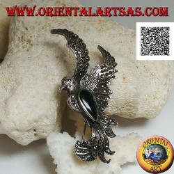 Silver brooch in the shape of a phoenix in flight in profile studded with marcasite and with a drop of onyx