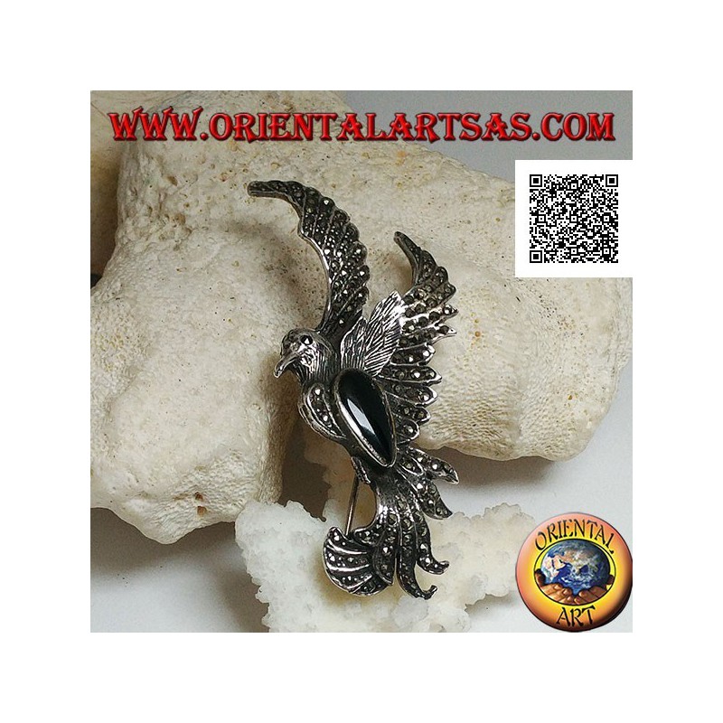 Silver brooch in the shape of a phoenix in flight in profile studded with marcasite and with a drop of onyx